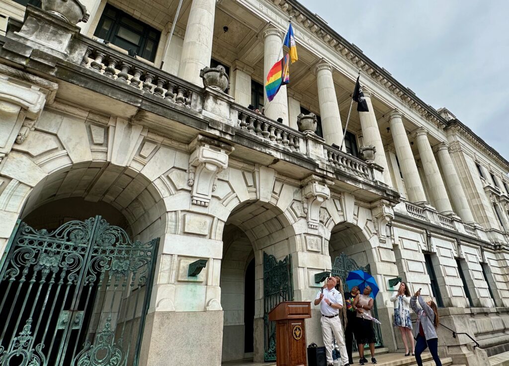 Mayor Gusciora, Members of City Council, and Quaysean Williams applaud at the rising of the Pride Flag